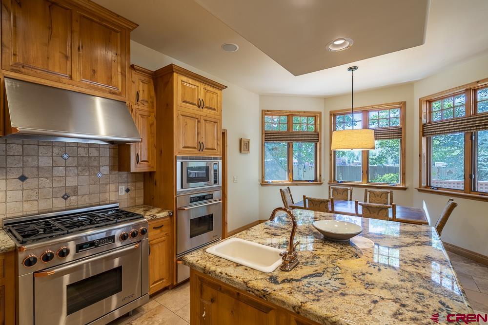 970 Red Rock Road Durango, CO 81301 - Photo 19 of 35 a kitchen with a stove a sink and a wooden cabinets