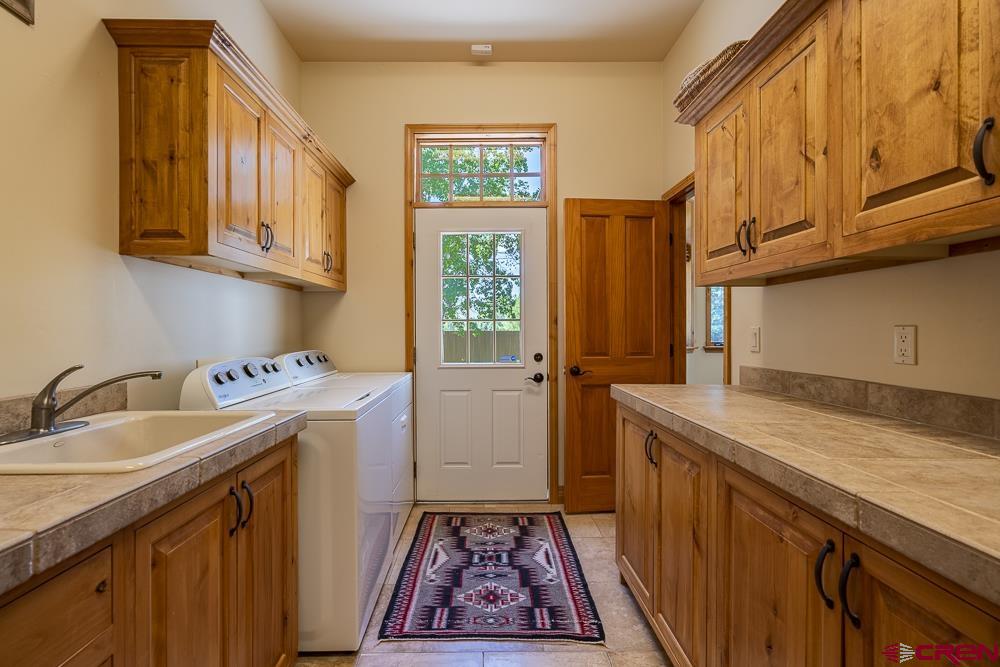 970 Red Rock Road Durango, CO 81301 - Photo 22 of 35 a utility room with a sink a washer and dryer