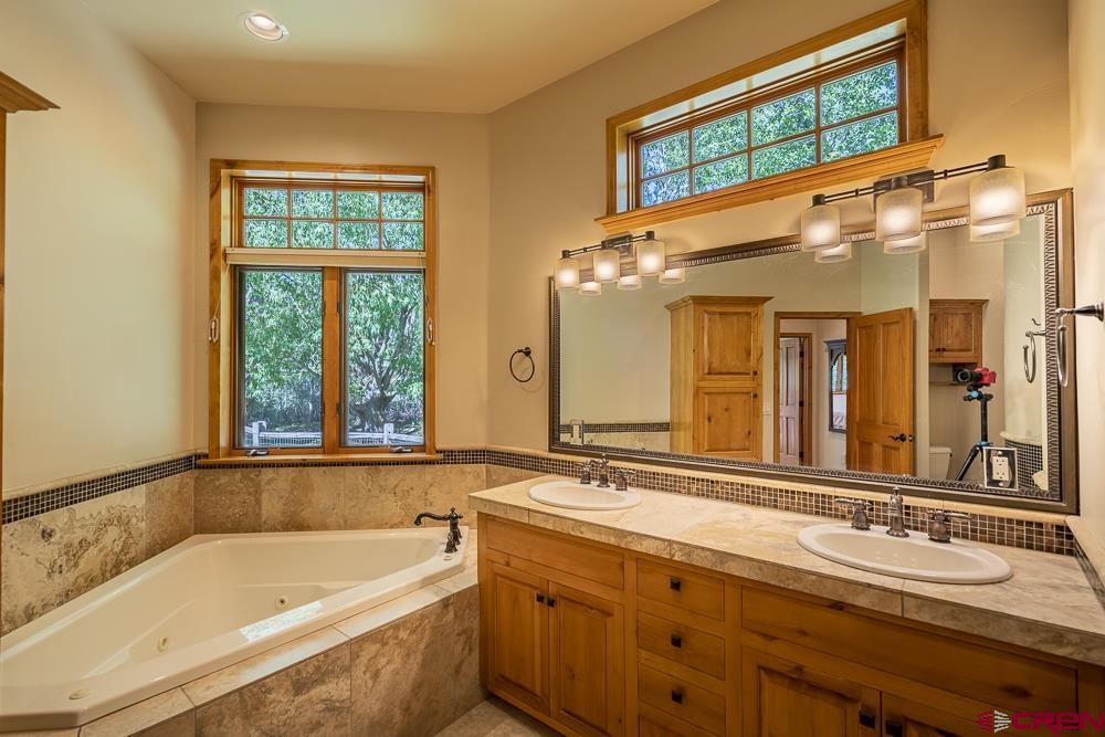 970 Red Rock Road Durango, CO 81301 - Photo 10 of 35 a bathroom with a tub a sink and a large mirror
