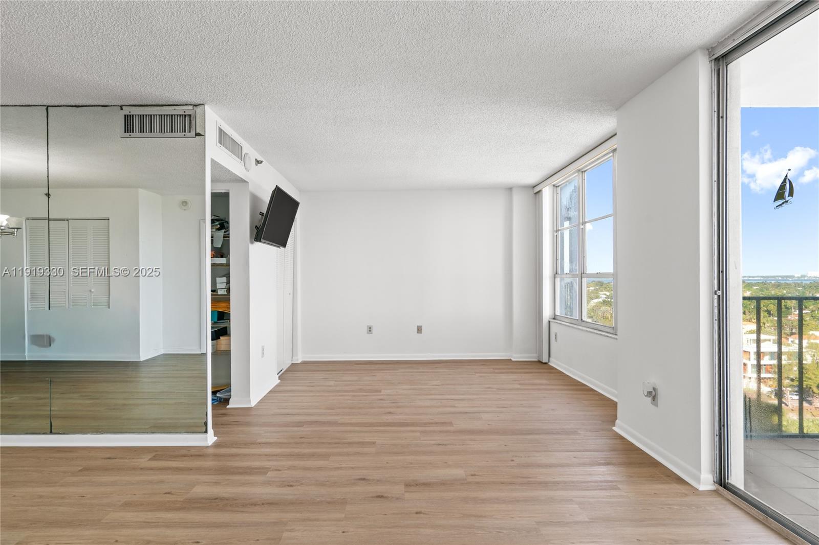 4101 Pine Tree Drive, Unit 1112 Miami Beach, FL 33140 - Photo 19 of 62 a view of an empty room with wooden floor and a window