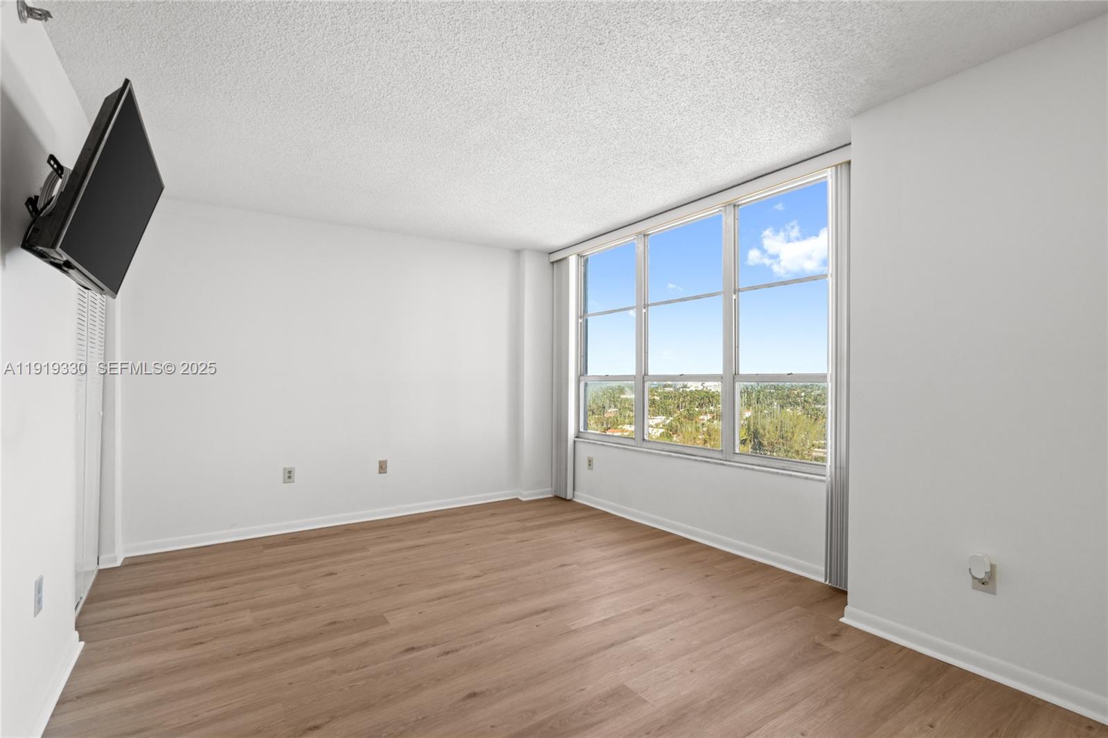 4101 Pine Tree Drive, Unit 1112 Miami Beach, FL 33140 - Photo 20 of 62 wooden floor in an empty room with a window