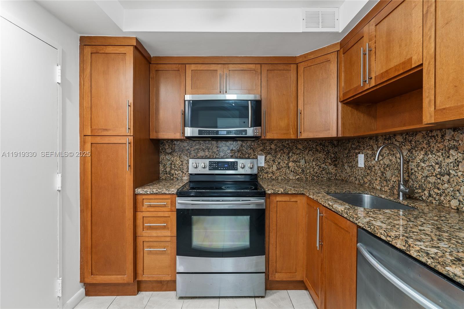 4101 Pine Tree Drive, Unit 1112 Miami Beach, FL 33140 - Photo 9 of 62 a kitchen with a stove and a microwave