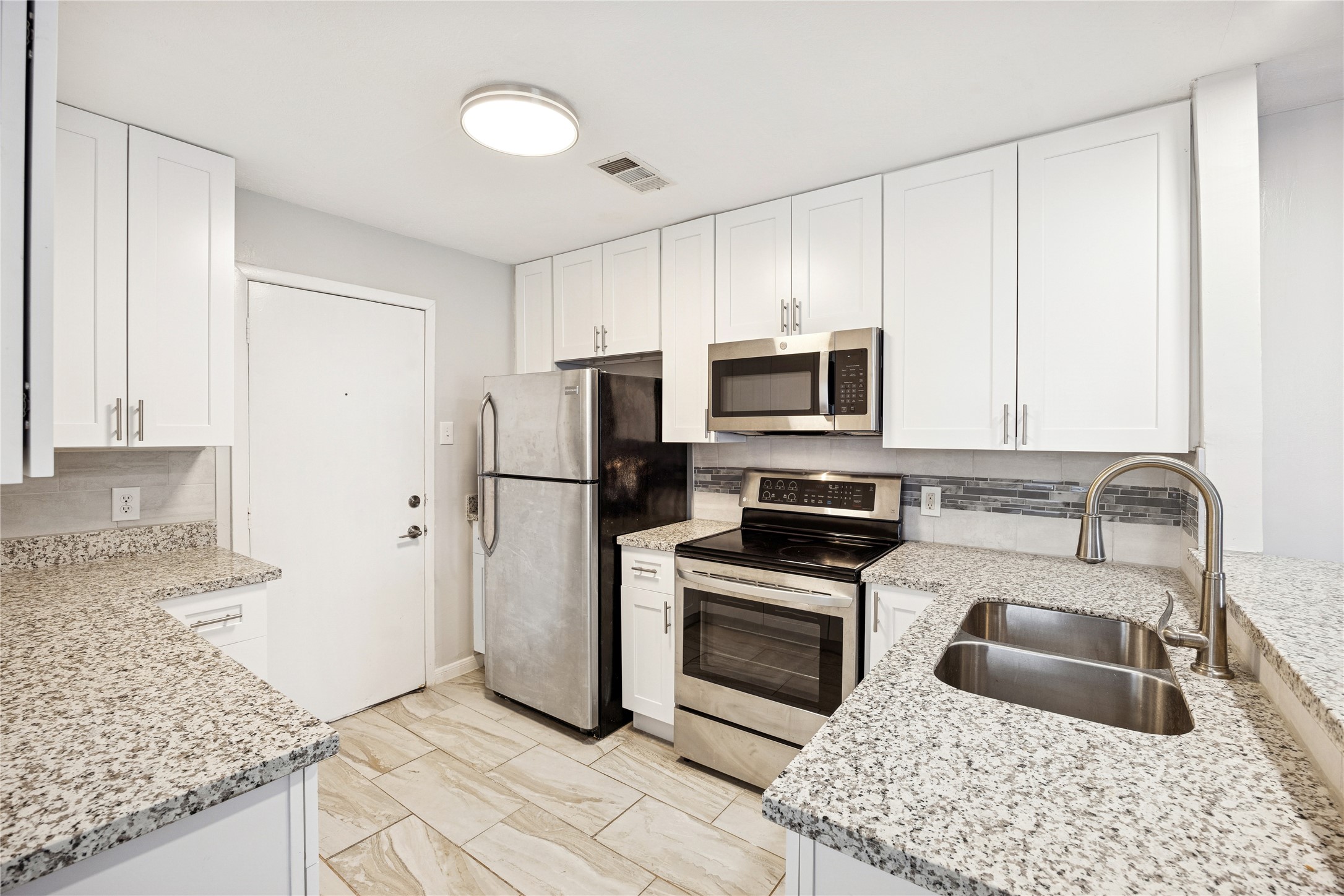 2614 Cleburne Street Houston, TX 77004 - Photo 5 of 17 a kitchen with granite countertop a refrigerator stove and sink