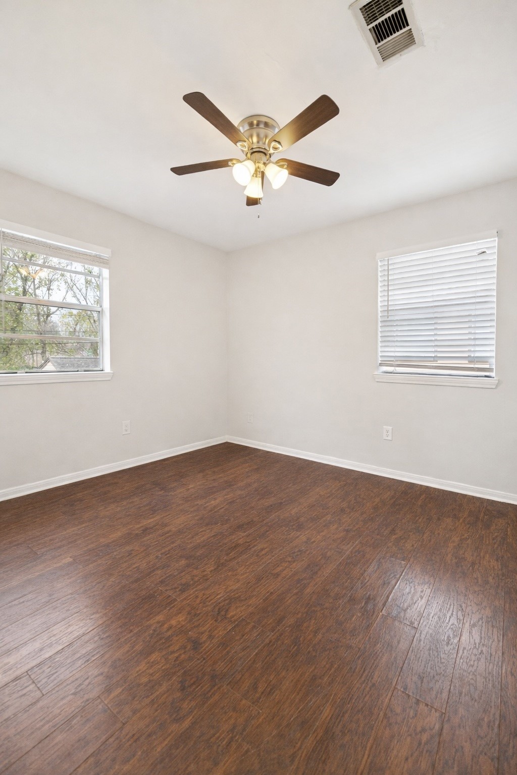 2614 Cleburne Street Houston, TX 77004 - Photo 8 of 17 an empty room with wooden floor fan and windows