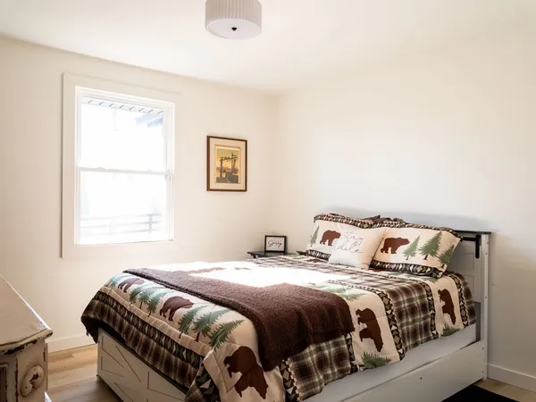 a bedroom with a bed two lamps and a window