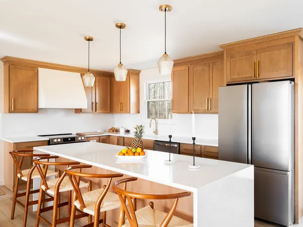 a kitchen with stainless steel appliances a refrigerator a sink a stove and a wooden floors