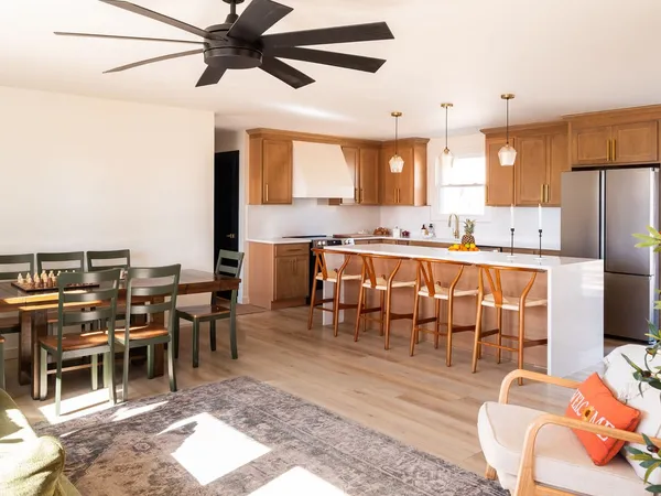 a living room with stainless steel appliances kitchen island granite countertop furniture and a dining table