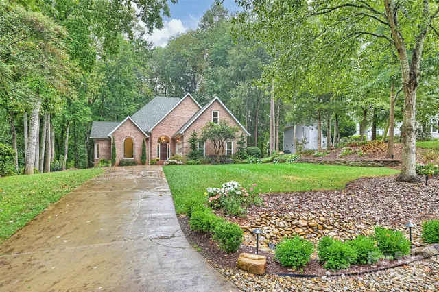 a front view of a house with a yard and green space