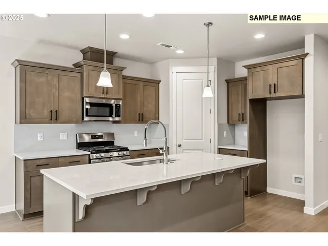 a kitchen with kitchen island a sink stainless steel appliances and white cabinets