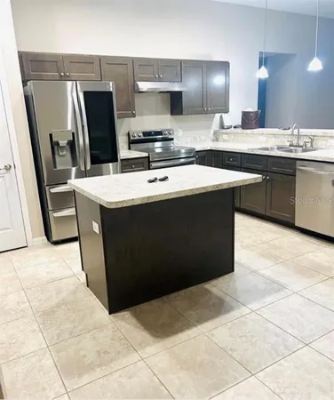 a kitchen with stainless steel appliances a sink stove and refrigerator