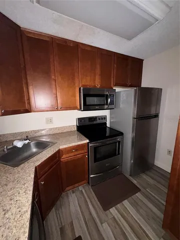 a kitchen with a refrigerator stove and cabinets