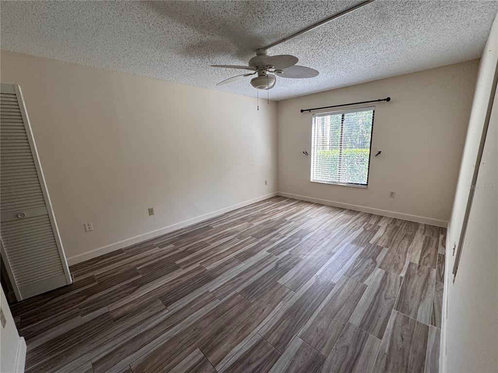 1372 Pine Ridge Circle East, Unit F1 Tarpon Springs, FL 34688 - Photo 2 of 21 a view of an empty room with wooden floor and a window