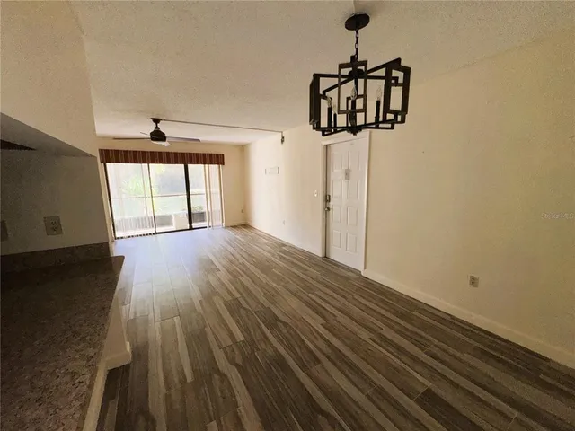 a view of a room with a window and wooden floor
