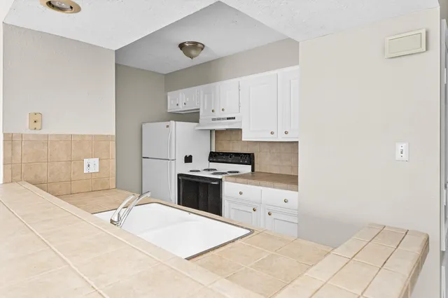 a large white kitchen with cabinets