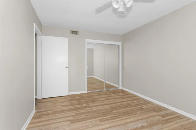 a view of an empty room with wooden floor