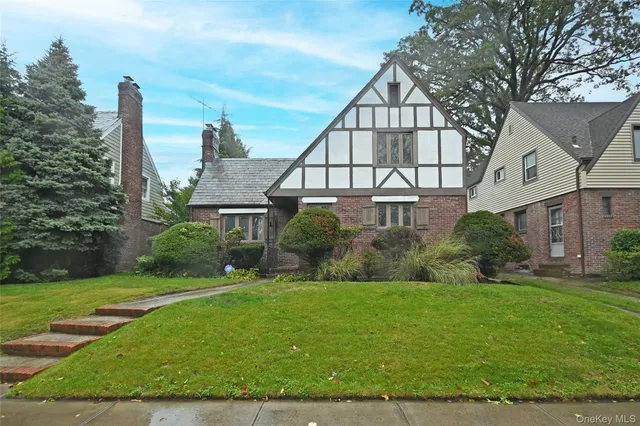 a view of a house next to a big yard and large trees