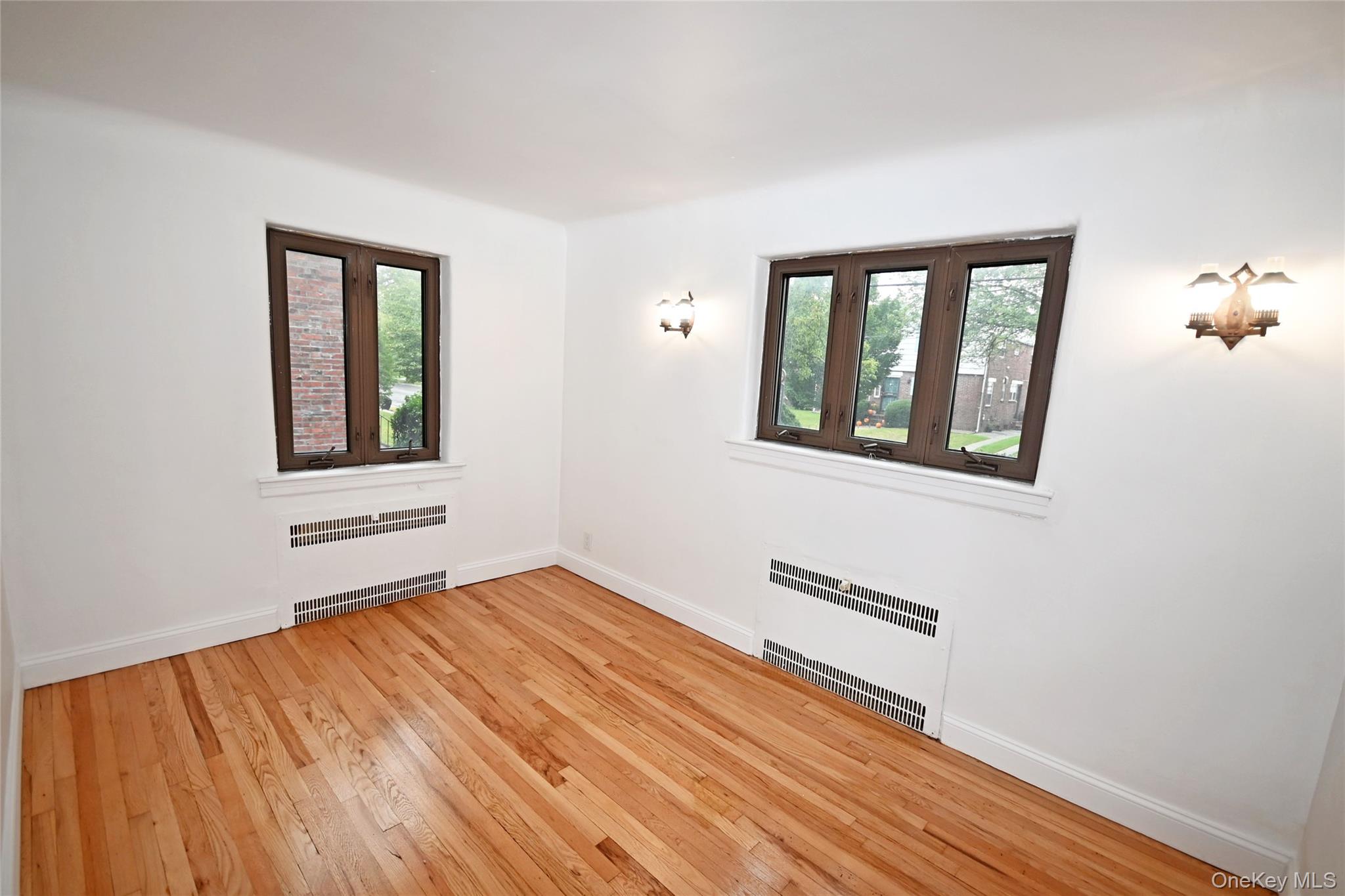 112-13 178th Street Queens, NY 11433 - Photo 14 of 28 Unfurnished room featuring radiator heating unit and light wood-style floors