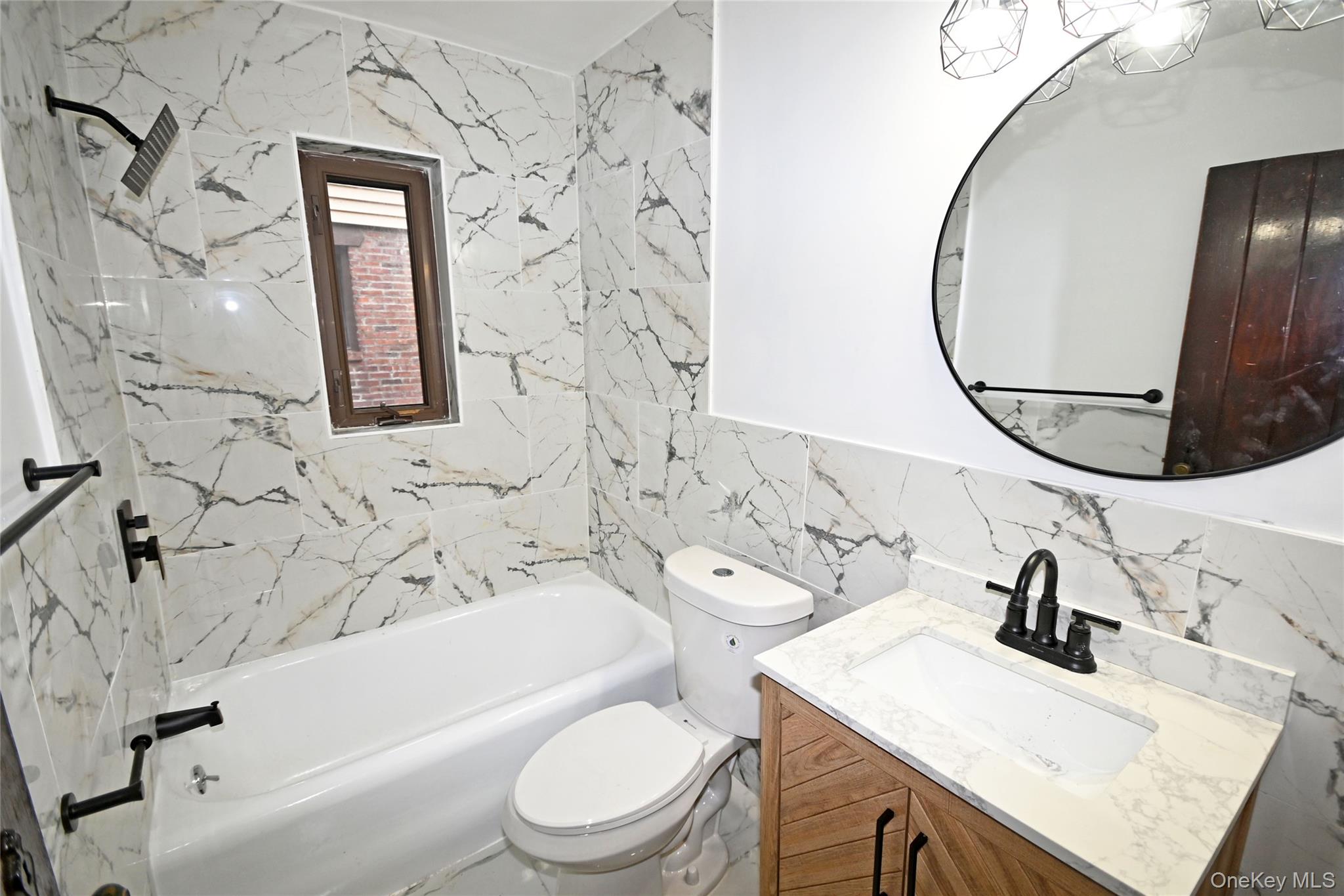 112-13 178th Street Queens, NY 11433 - Photo 16 of 28 Full bathroom featuring tile walls, vanity, and bathing tub / shower combination