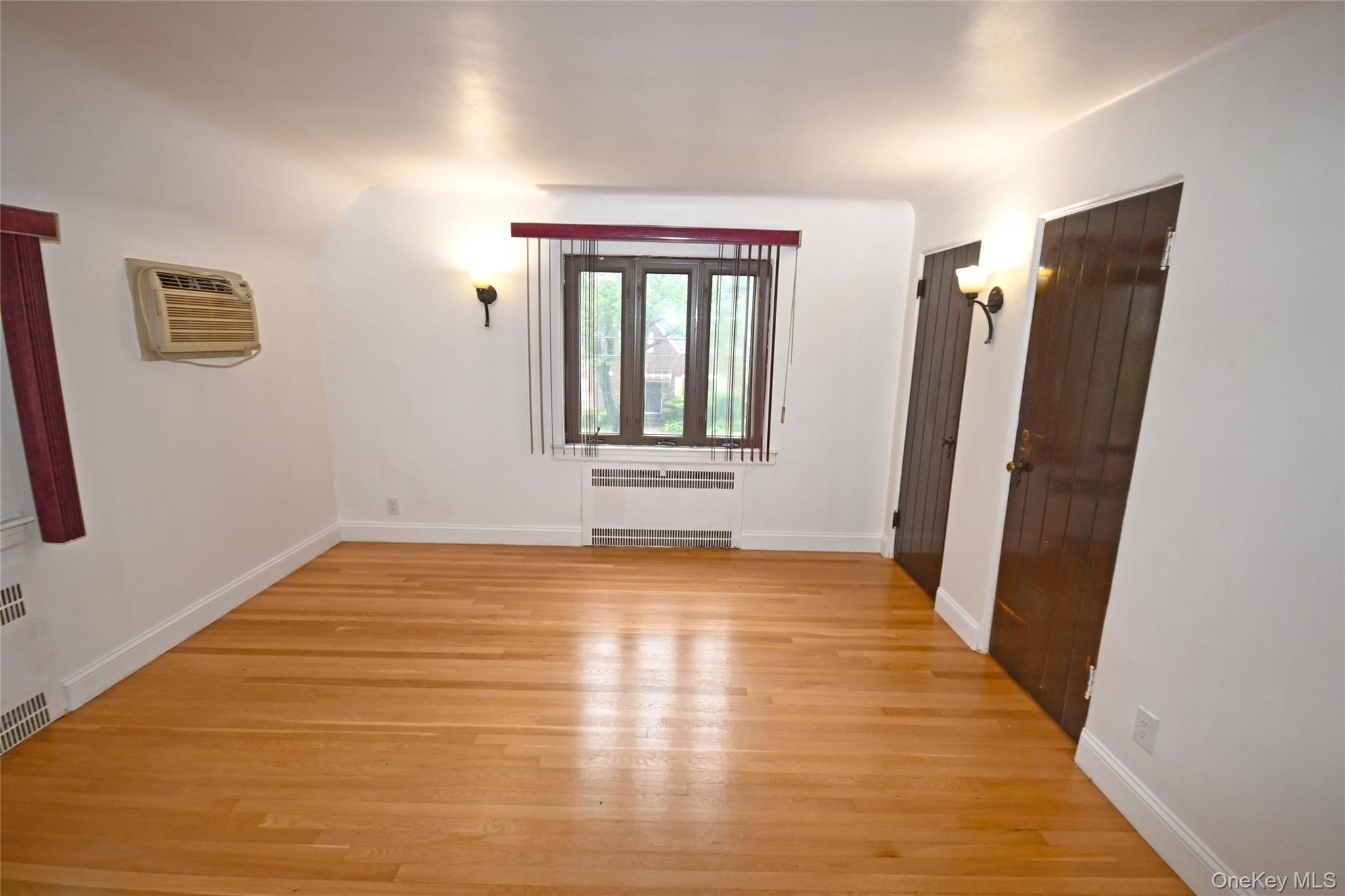 112-13 178th Street Queens, NY 11433 - Photo 21 of 28 Spare room with light wood finished floors and a wall mounted air conditioner