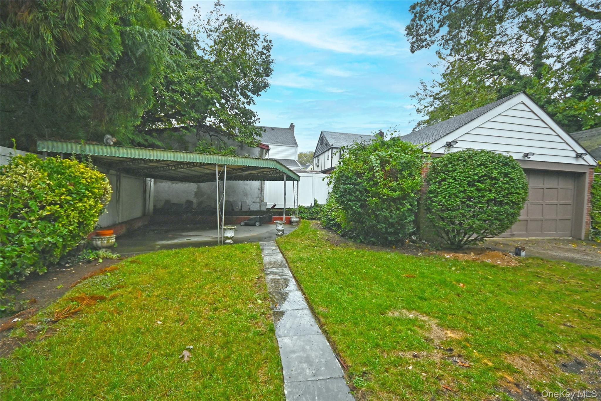 112-13 178th Street Queens, NY 11433 - Photo 28 of 28 View of green lawn with an outdoor structure, a garage, and a patio