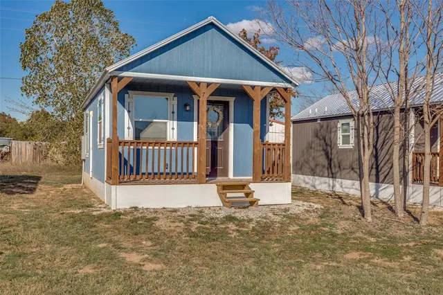a view of the house with wooden fence next to a road
