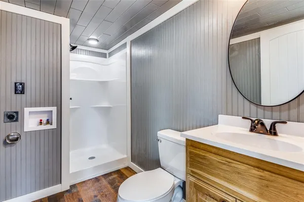 a bathroom with a sink a toilet and shower