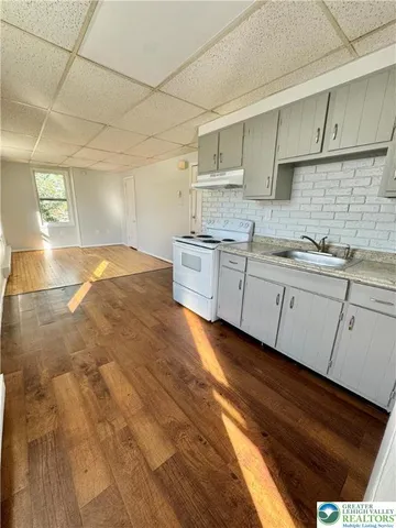 a kitchen with granite countertop a sink and white cabinets