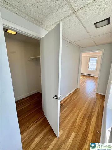 a view of a hallway with wooden floor and stairs