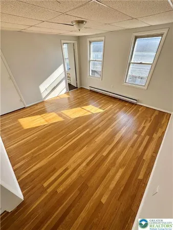 a view of a room with wooden floor and windows
