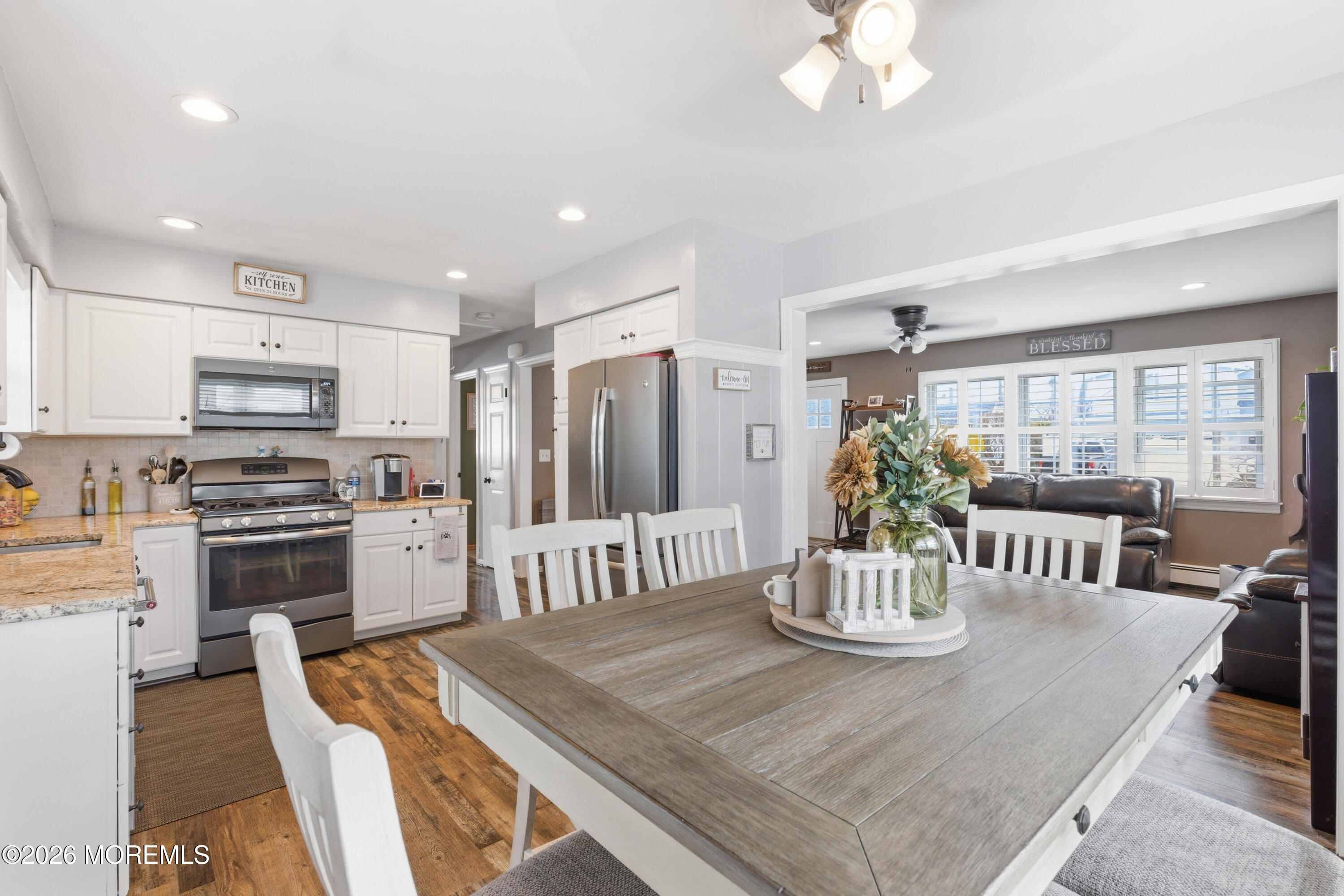 1155 Lockhart Lane Point Pleasant, NJ 08742 - Photo 12 of 33 a kitchen with stainless steel appliances kitchen island granite countertop a refrigerator a stove a sink dishwasher and a dining table with wooden floor