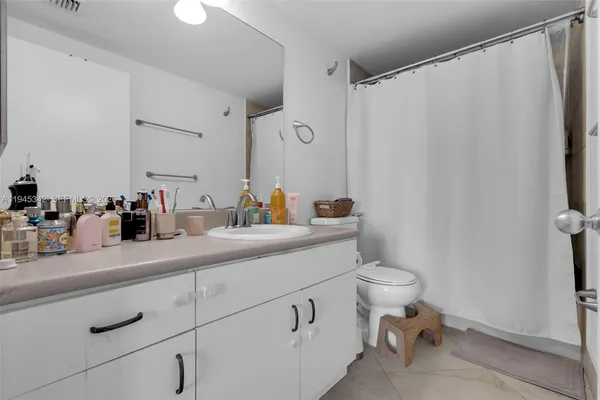 a bathroom with a granite countertop toilet sink and mirror