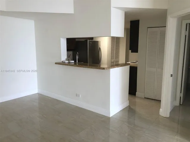 a kitchen with granite countertop a refrigerator and a sink