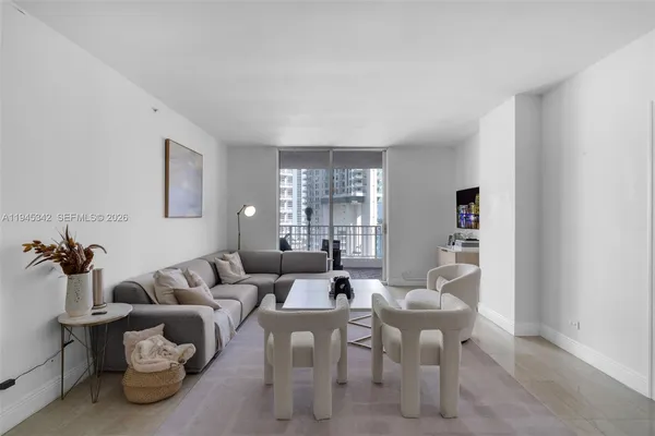 a living room with furniture and a view of kitchen