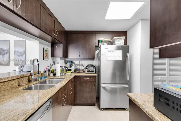a kitchen with a sink a stove top oven and wooden floor