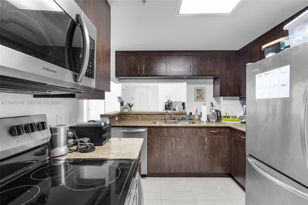 a kitchen with stainless steel appliances a stove a microwave a sink and wooden cabinets