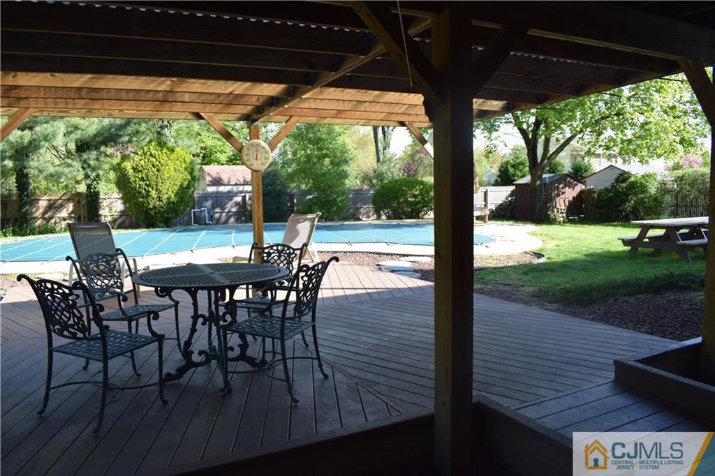 10 Harper Road Monmouth Junction, NJ 08852 - Photo 21 of 24 a view of a patio with table and chairs under an umbrella with a small yard