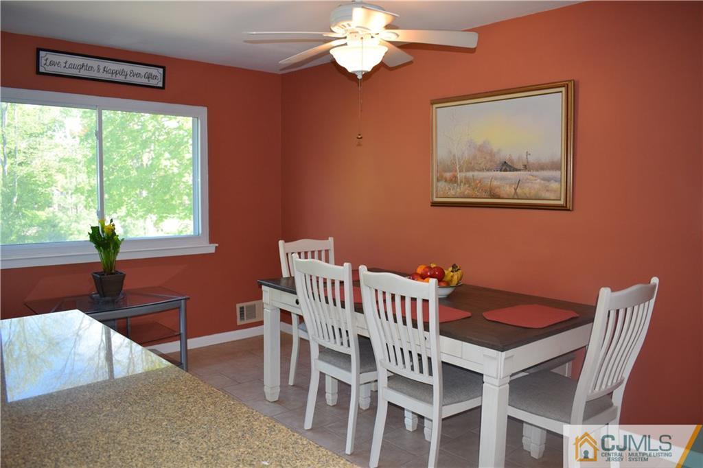 10 Harper Road Monmouth Junction, NJ 08852 - Photo 7 of 24 a view of a dining room with furniture a chandelier and a window