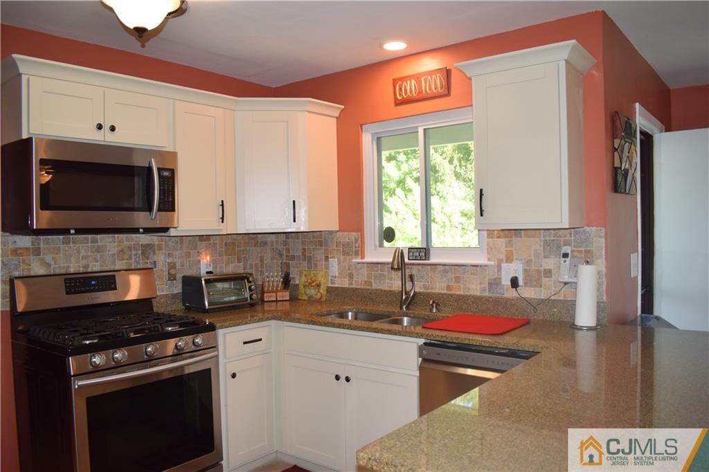 10 Harper Road Monmouth Junction, NJ 08852 - Photo 9 of 24 a kitchen with stainless steel appliances a stove a sink a microwave and cabinets