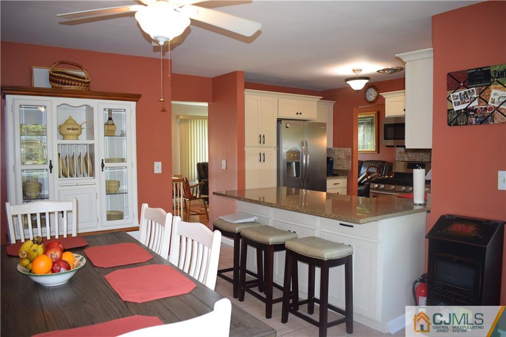 10 Harper Road Monmouth Junction, NJ 08852 - Photo 10 of 24 a kitchen with stainless steel appliances granite countertop a dining table chairs and chandelier