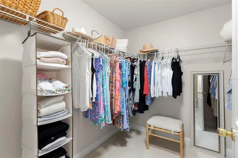 a view of walk in closet with clothes and shoes