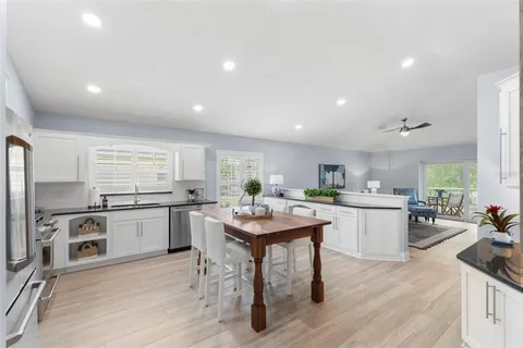 a kitchen with a sink a stove a refrigerator and chairs