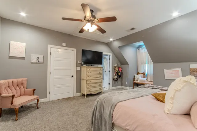 a spacious bedroom with a bed and a flat screen tv