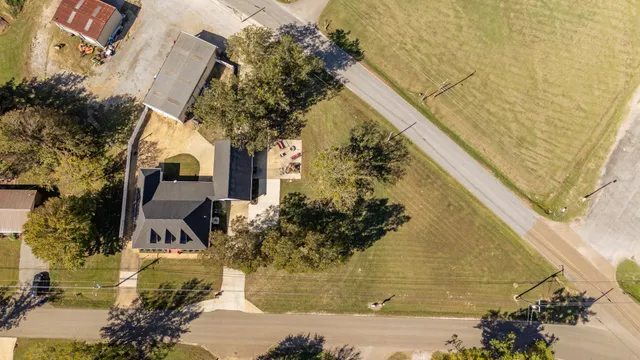 a big white house with a yard and large trees