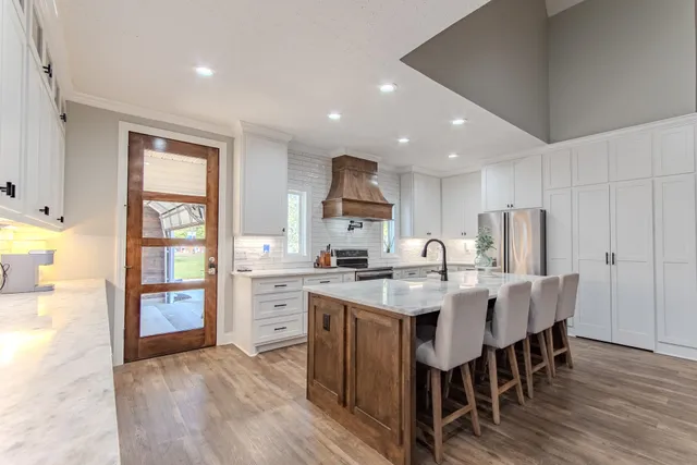 a open kitchen with stainless steel appliances granite countertop a refrigerator and a stove top oven