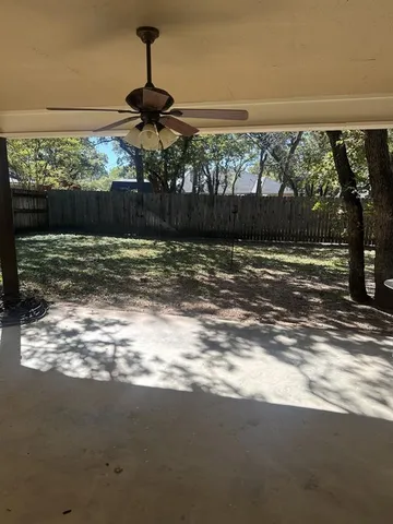 a view of a yard with a wooden fence