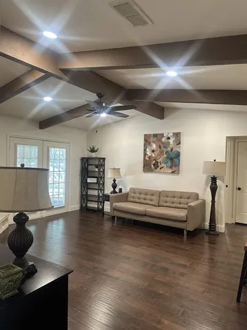 a living room with furniture and wooden floor