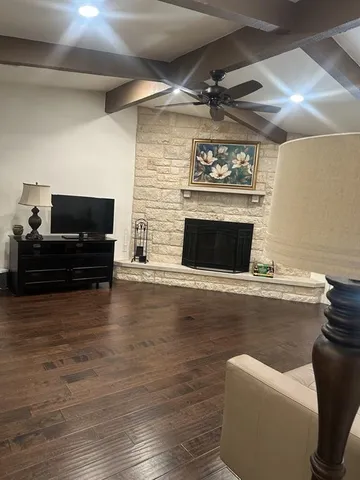 a living room with furniture a fireplace and a flat screen tv