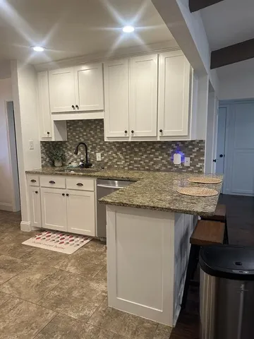 a kitchen with stainless steel appliances granite countertop a sink stove and cabinets