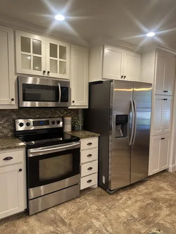 a kitchen with stainless steel appliances and granite countertop a stove top oven