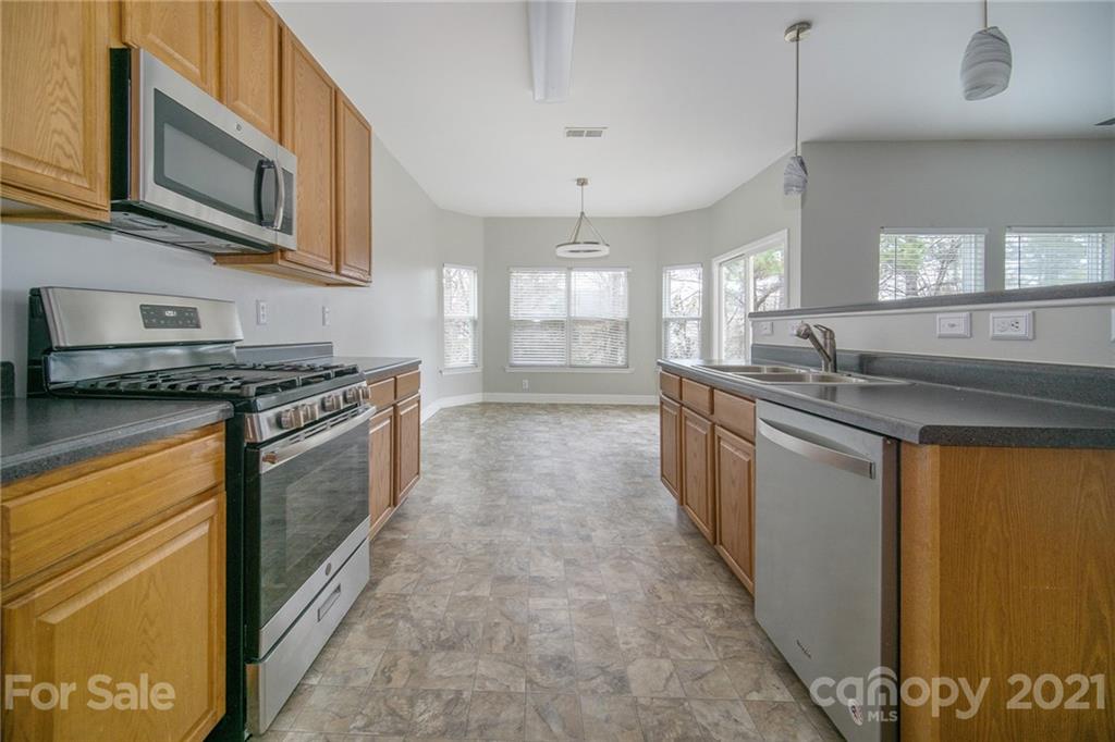 382 Primrose Walk Fort Mill, SC 29715 - Photo 2 of 20 a kitchen with stainless steel appliances granite countertop a stove a sink and a microwave
